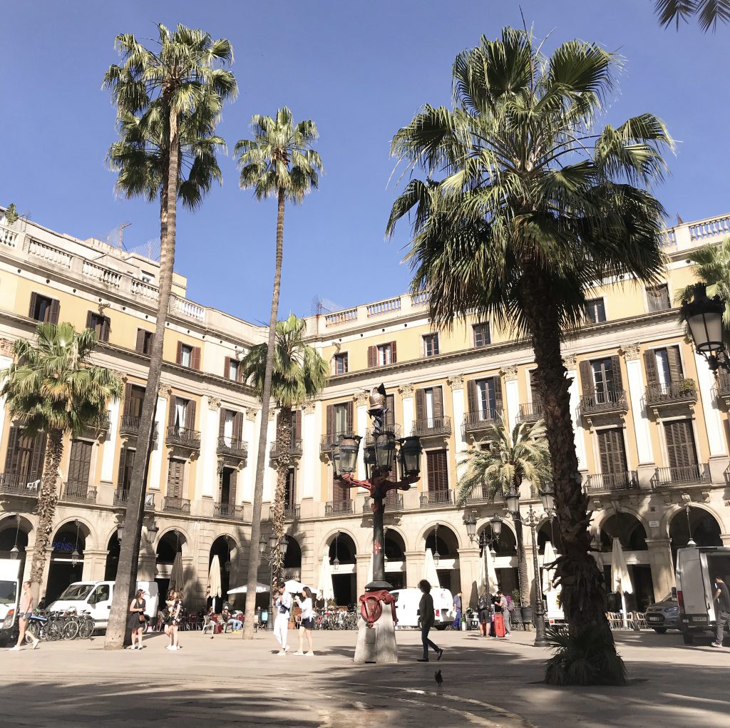 The yellow building with the famous palm trees in the middle of Plaza Reial in the Gothic Quarter of Barcelona, Spain