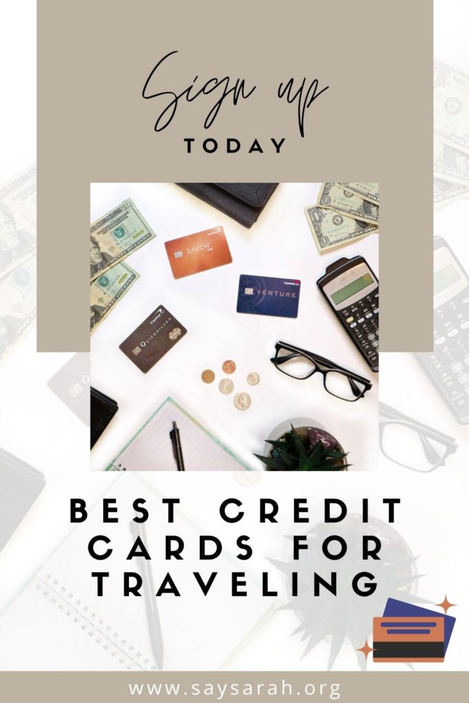 A flat lay with the best credit cards for traveling and other items such as pen, paper, glasses, calculator.