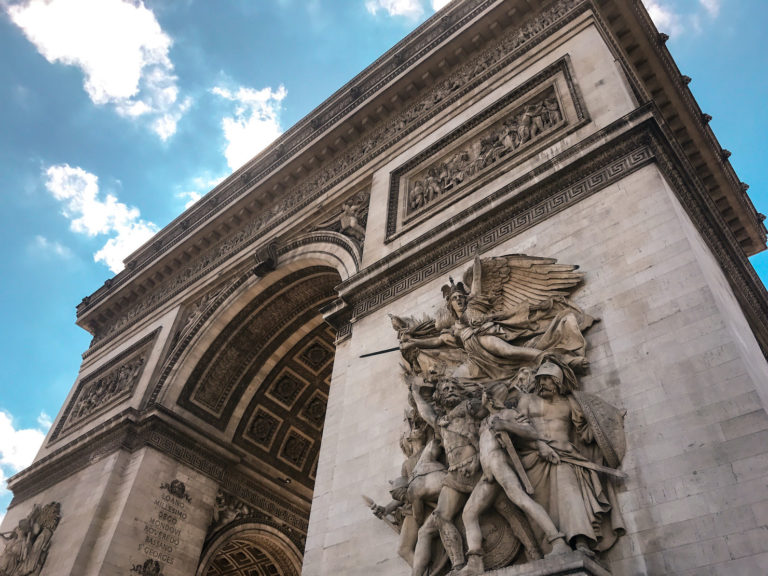 An image of the Arc de Triomphe from the ground view in Paris, France.