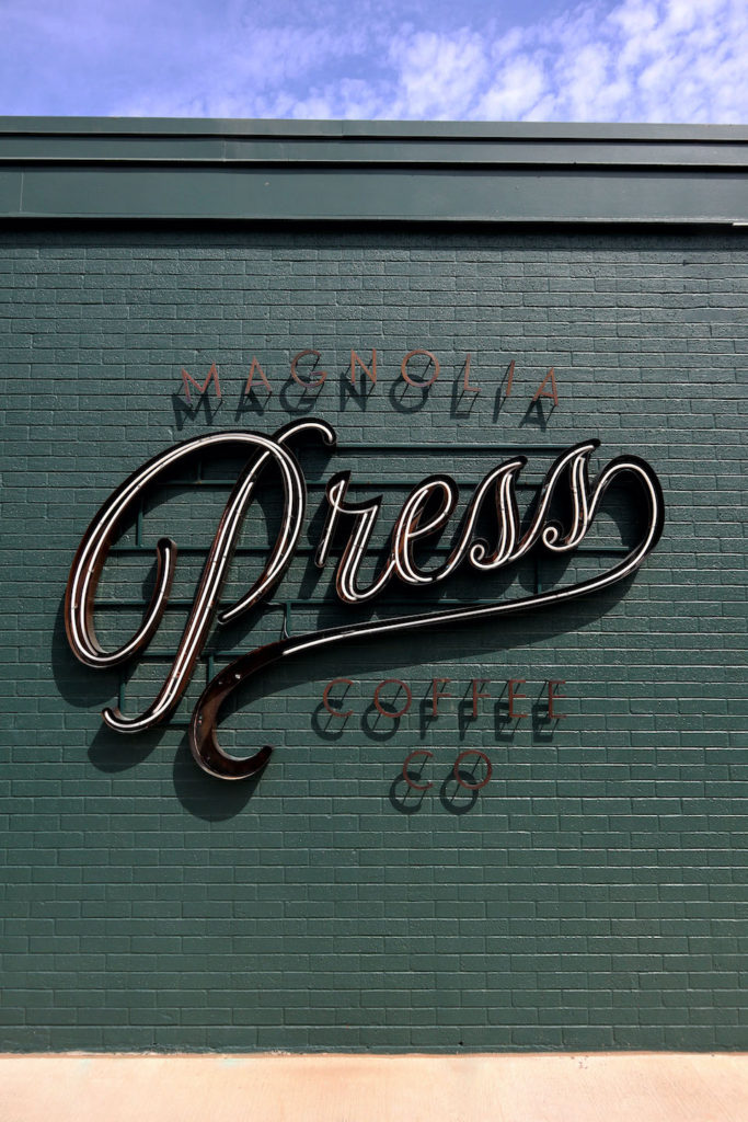 A picture of the Magnolia Press sign outside of their building at the Magnolia Market in Waco, Texas.