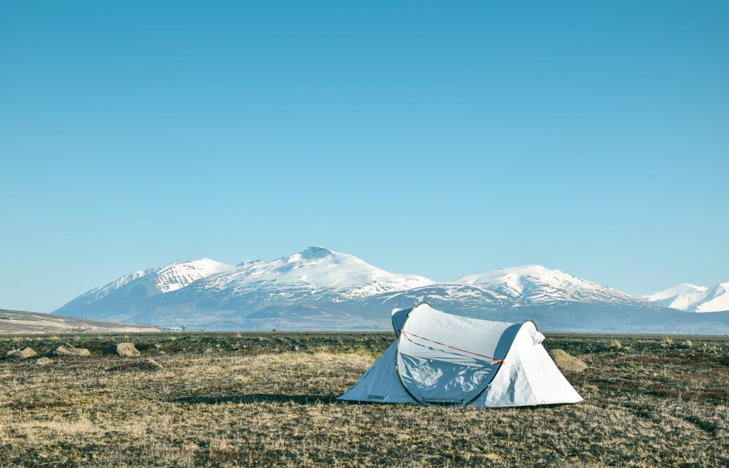 An image of a tent in nature representing going camping as a travel new year's resolution.