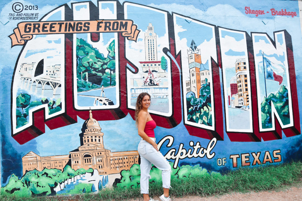 In front of the Greetings from Austin, Texas mural during my Texas Road Trip.
